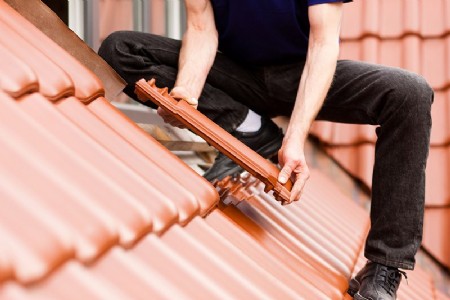 Dachdecker legt Dachziegel